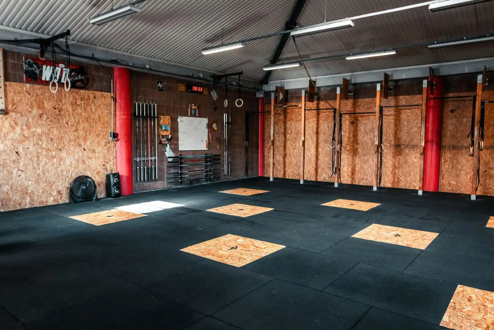 La salle d'entraînement de la box CrossFit Woda à Gap, le rig et le chronomètre au mur.